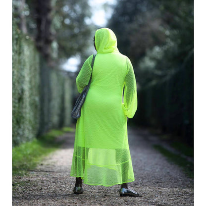 Women's Aphrodite Neon Lime Holiday Resort Dress with hoodie and matching neon lime undergarment shown from the back, styled with a silver  handbag and silver flats.