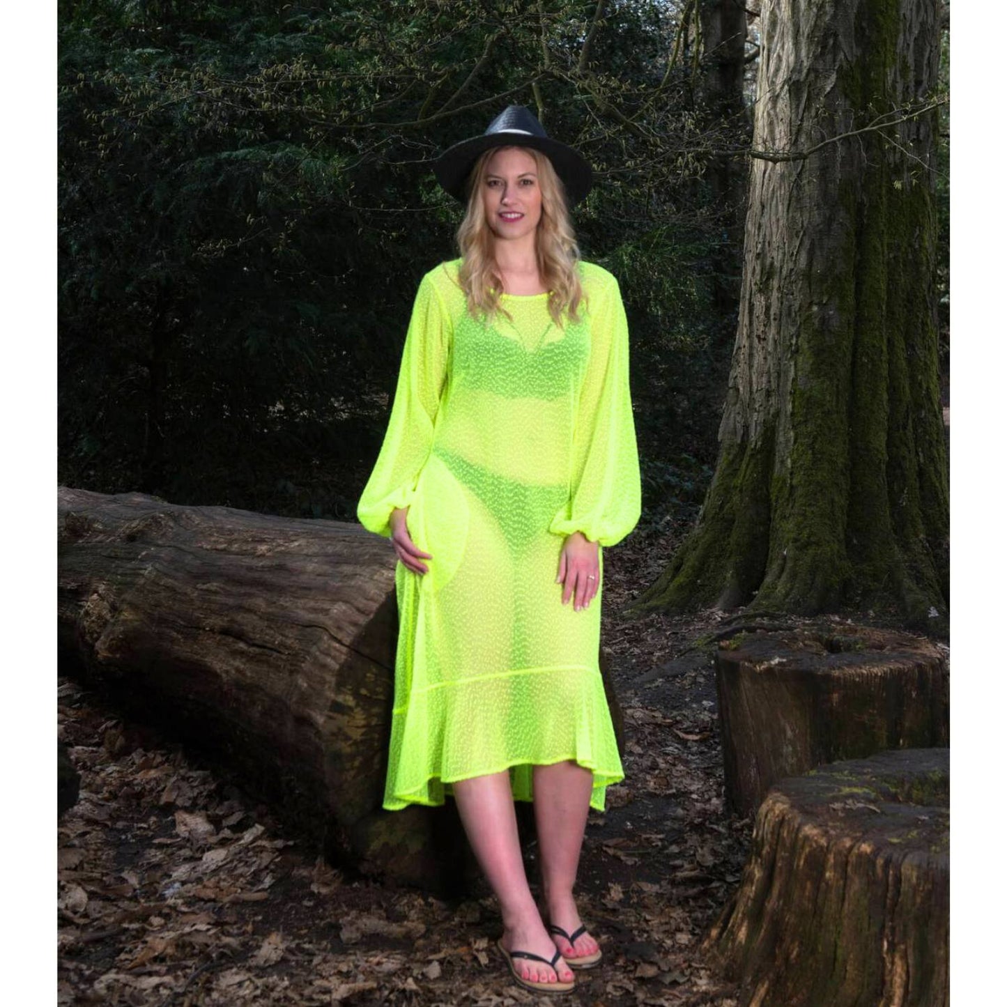 Women's Aphrodite Neon Lime Holiday Resort Dress styled with a bikini underneath, paired with a black hat and black flip-flops for a casual look.