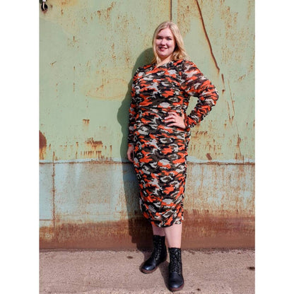 Women's Plus Size Orange Green Grey Camouflage Bodycon Midi Dress styled with black boots for a fashionable and edgy ensemble.