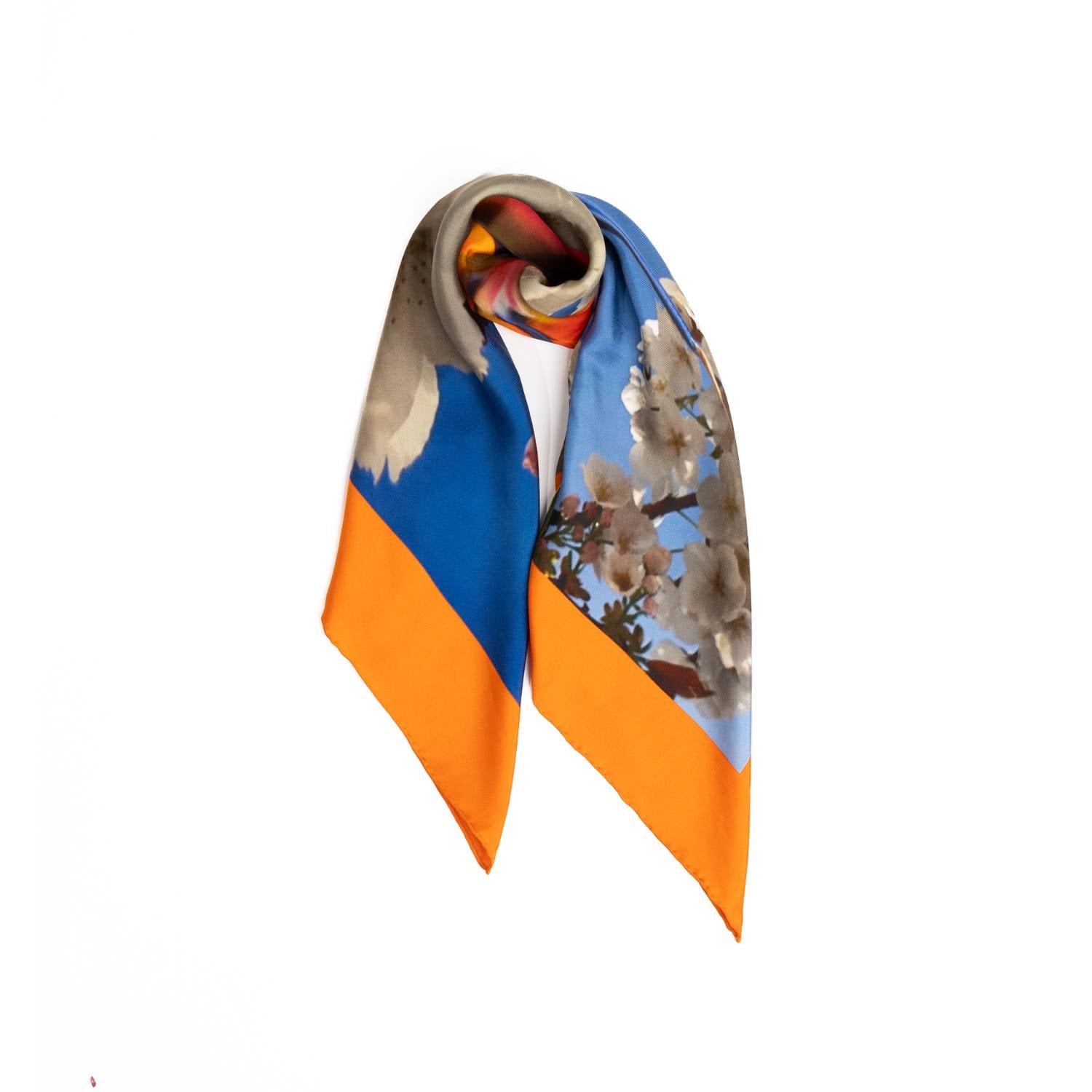 Silk scarf showcasing an Orange Bird of Paradise with White and Blue Cherry Blossom print, displayed as a cutout to highlight its intricate design.