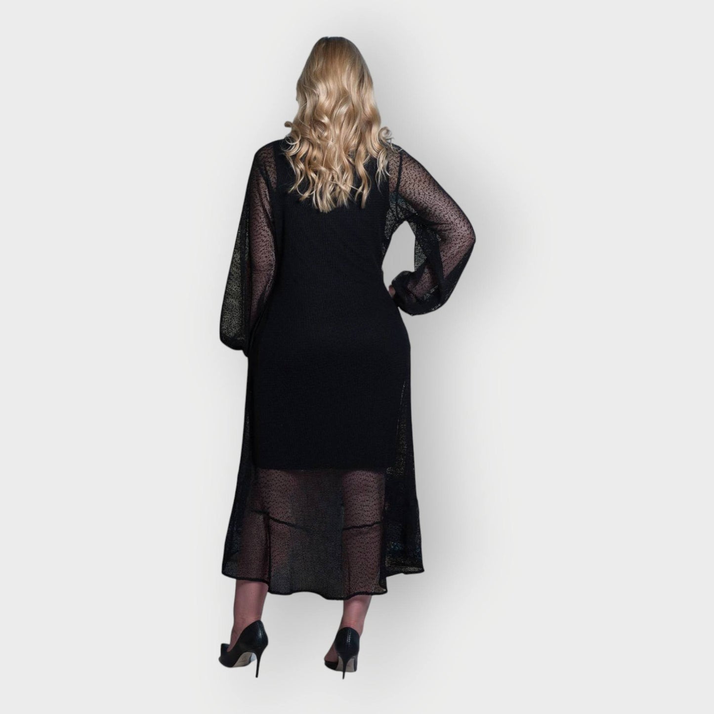 Women's Aphrodite Black Holiday Resort Dress with black undergarment, styled with black heels.
