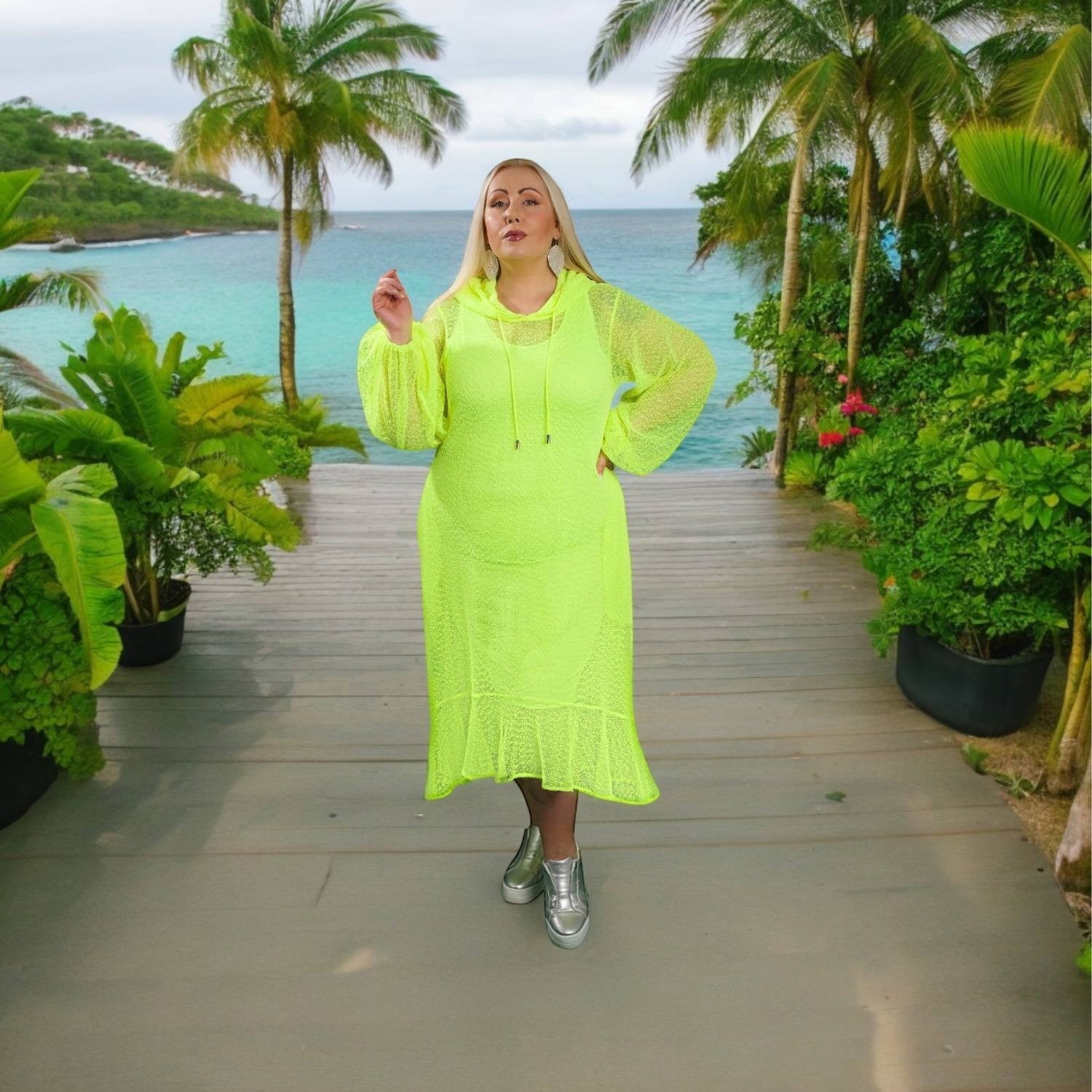 Sylvia Piechulla neon lime mesh midi dress with hoodie and bishop sleeves worn by a blonde model on a tropical deck.