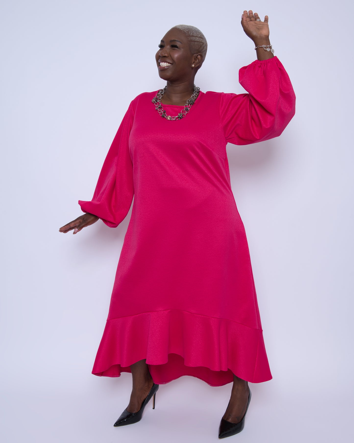 Women's Plus Size Pink Magenta Midi Dobby Jacquard styled with silver chain jewelry and black heels for an elegant and sophisticated ensemble.