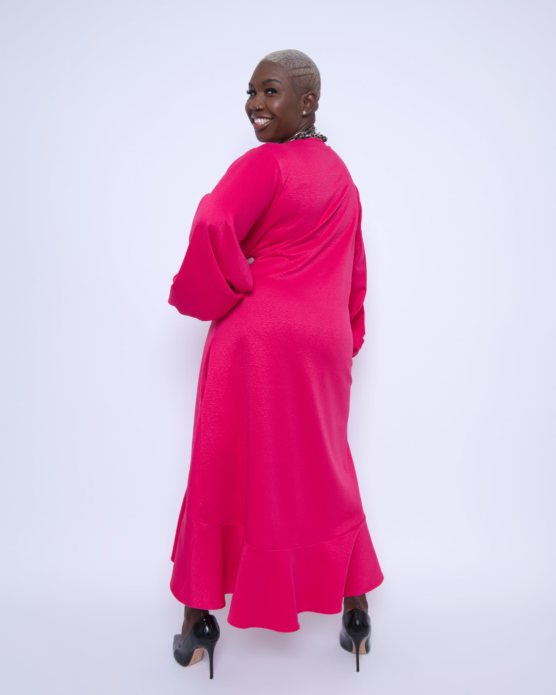 Women's Plus Size Pink Magenta Midi Dobby Jacquard shown from the back, styled with black heels for an elegant and sophisticated ensemble.